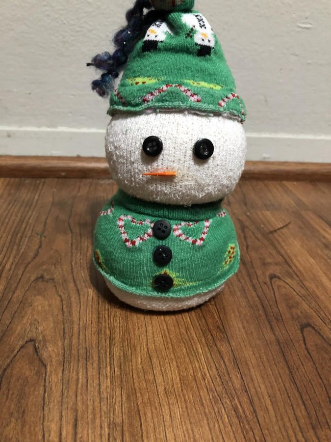  Step 11: Take a toothpick and color the pointy end of it orange, then cut the toothpick so you only have the colored end. Glue the toothpick onto the head of the snowman.  Step 12: Enjoy your cute sock snowman, use it as a decoration for yourself or gift it to a friend or loved one! 
